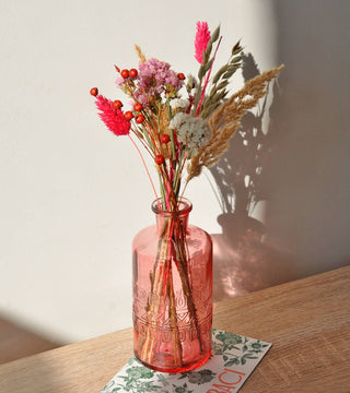 Bouquet of dried flowers in a red glass vase